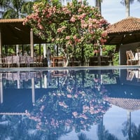 PISCINA COM QUIOSQUE AO FUNDO