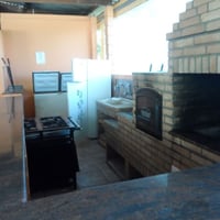 Cozinha do salão de festas: churrasqueira, fogão/forno a lenha, fogão industrial, pia, 02 freezers.