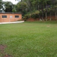 Campo de futebol gramado em frente ao salão de festas e piscinas
