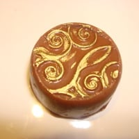 bombom de castanha com arabescos em dourado