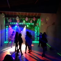 Festa com iluminação e som, estrutura em trave com efeito neon