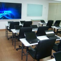 Auditório 1 com mesas e notebooks
