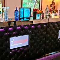 Bar clássico em capitonê preto com monitores