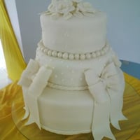 Bolo de casamento de três andares com laços.